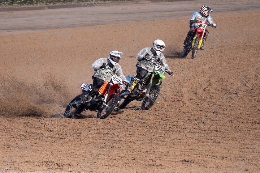 موتورسوار در حال مسابقه موتور روی شن‌زار (sand racing) — حرکت پرسرعت در فضای باز