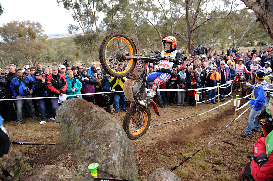 موتورسوار در مسابقات Trials در حال عبور از موانع سنگی و شیب‌دار با حفظ تعادل دقیق