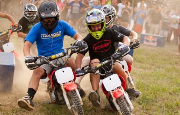 مسابقه پیت‌بایک (Pit Bike) روی پیستی خاکی با موتورسیکلت‌های کوچک در حال پیچیدن و رقابت